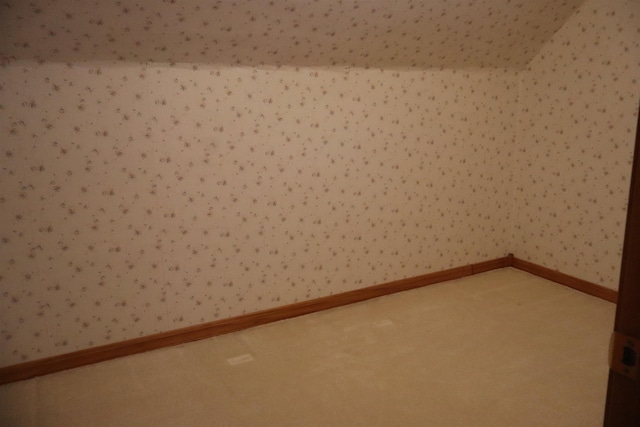 empty room with wallpapered walls, carpet, and baseboards