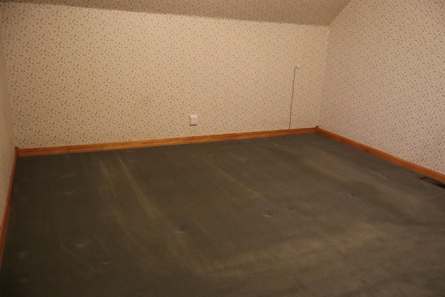 empty room with visible vents, baseboards, dark wood finished floors, and wallpapered walls