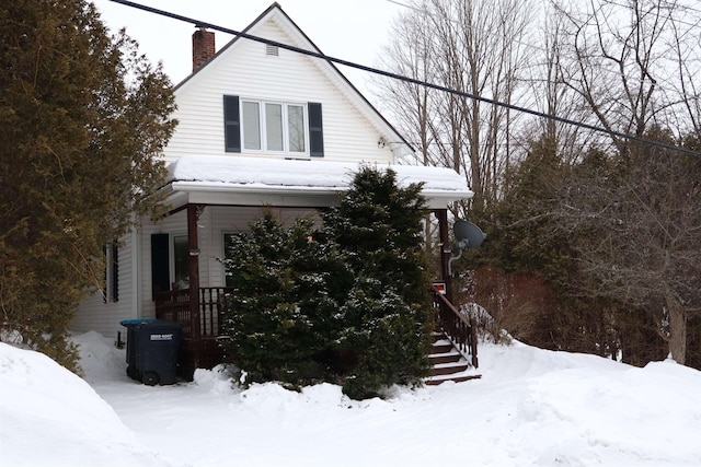 snow covered property featuring a chimney