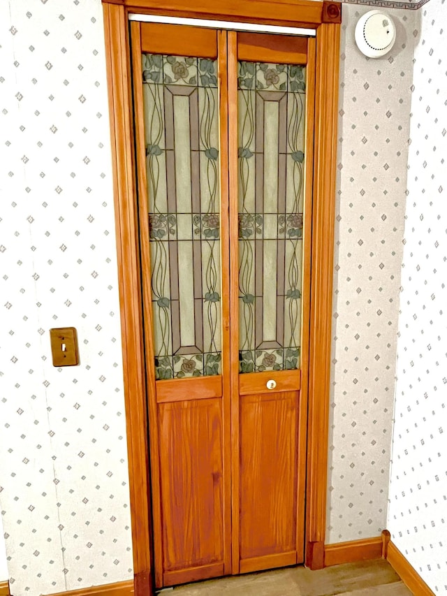 room details featuring baseboards, wood finished floors, and wallpapered walls