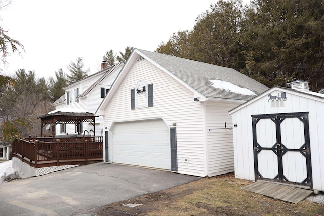 exterior space featuring a storage unit and aphalt driveway