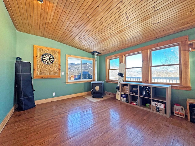 game room featuring a wood stove, a wealth of natural light, wood finished floors, and lofted ceiling