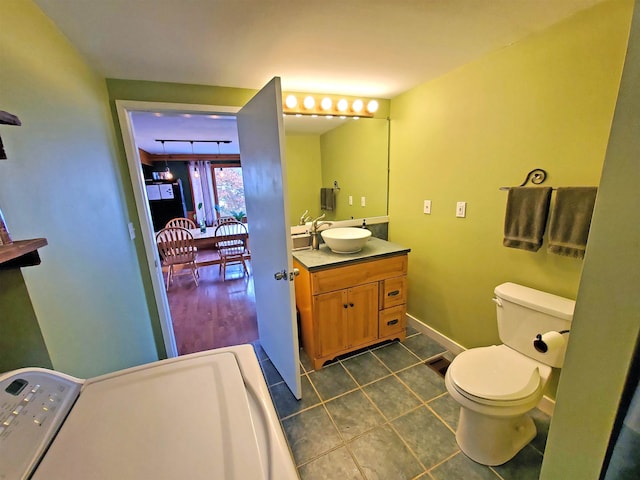 bathroom featuring baseboards, vanity, toilet, and tile patterned floors