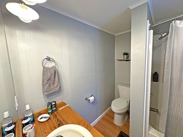 bathroom with toilet, baseboards, ornamental molding, and wood finished floors