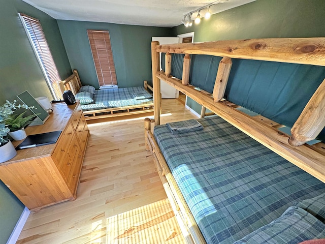 bedroom with light wood-type flooring and track lighting