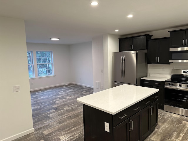 kitchen with a center island, dark wood finished floors, stainless steel appliances, light countertops, and baseboards