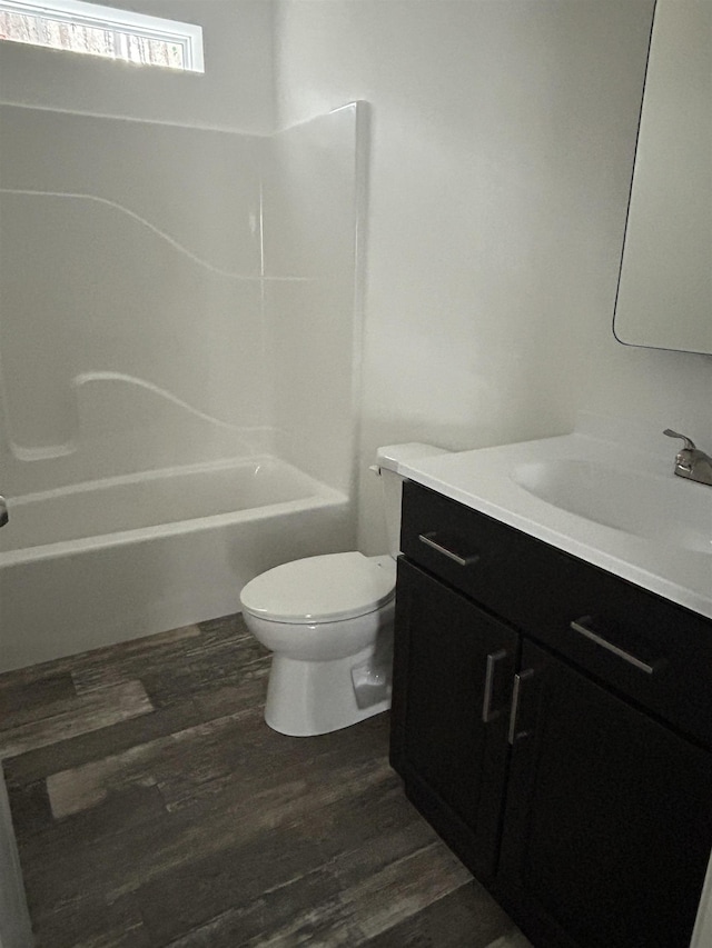 bathroom featuring tub / shower combination, vanity, toilet, and wood finished floors