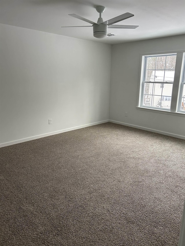 empty room featuring a ceiling fan, carpet, and baseboards