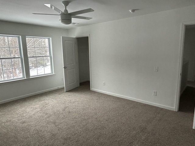 unfurnished bedroom featuring carpet floors, a closet, baseboards, and a ceiling fan