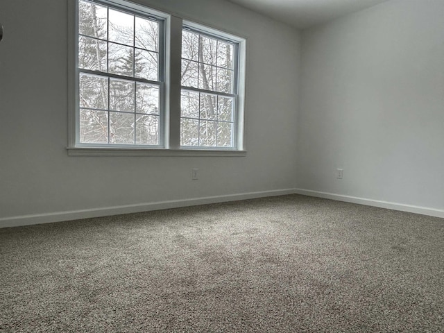 carpeted spare room featuring baseboards