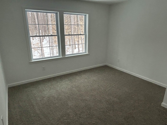 carpeted spare room with baseboards