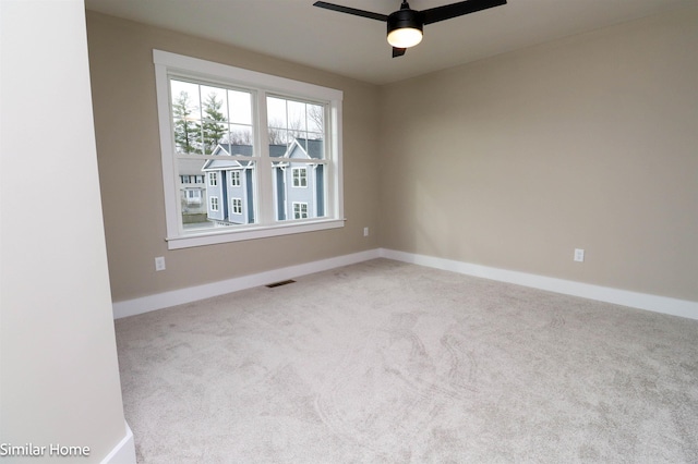 spare room with light carpet, visible vents, and baseboards