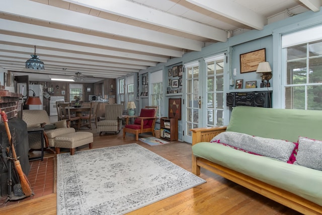 interior space with beamed ceiling, wood finished floors, and a ceiling fan