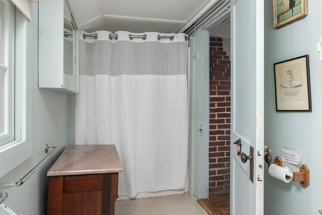 bathroom featuring brick wall