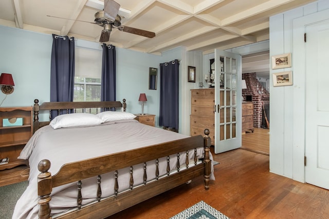 bedroom with french doors, beamed ceiling, coffered ceiling, and wood finished floors