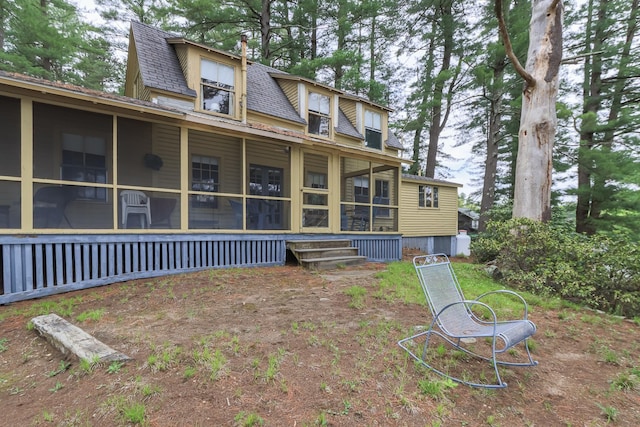 back of house with a sunroom and roof with shingles