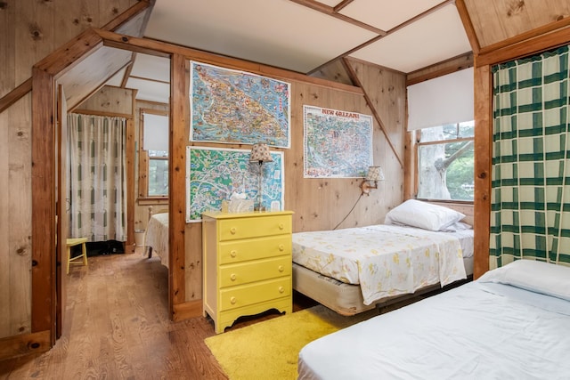 bedroom with wood walls and wood finished floors