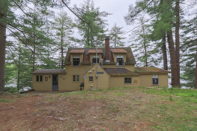 rear view of house featuring a chimney