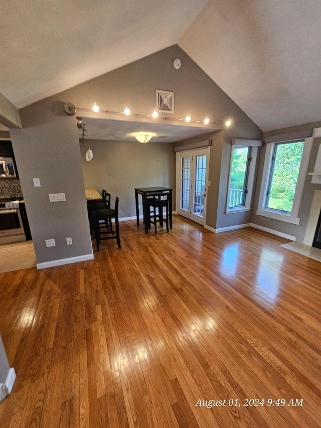 unfurnished living room featuring lofted ceiling, wood-type flooring, visible vents, and french doors