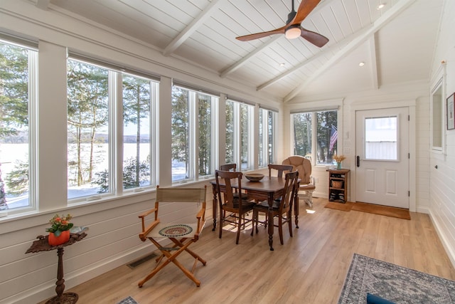 sunroom / solarium featuring visible vents, a water view, lofted ceiling with beams, a ceiling fan, and wooden ceiling