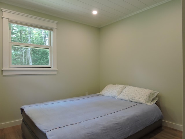 bedroom with dark wood-style floors, recessed lighting, ornamental molding, and baseboards