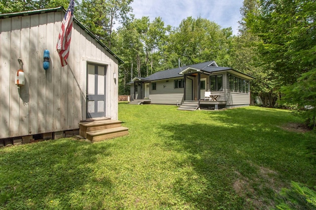 exterior space featuring entry steps and a lawn