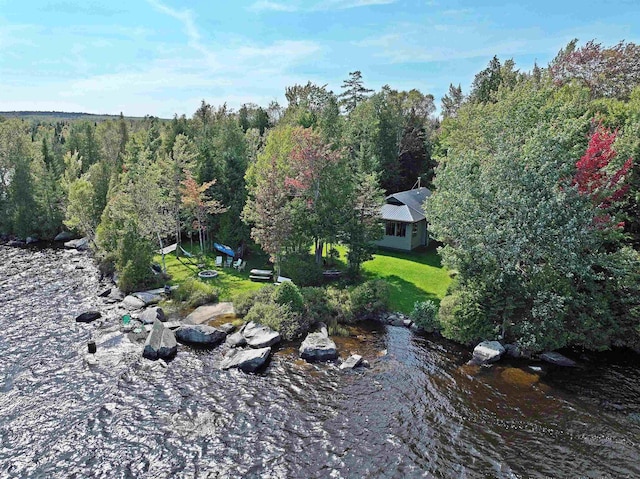 birds eye view of property featuring a water view and a wooded view