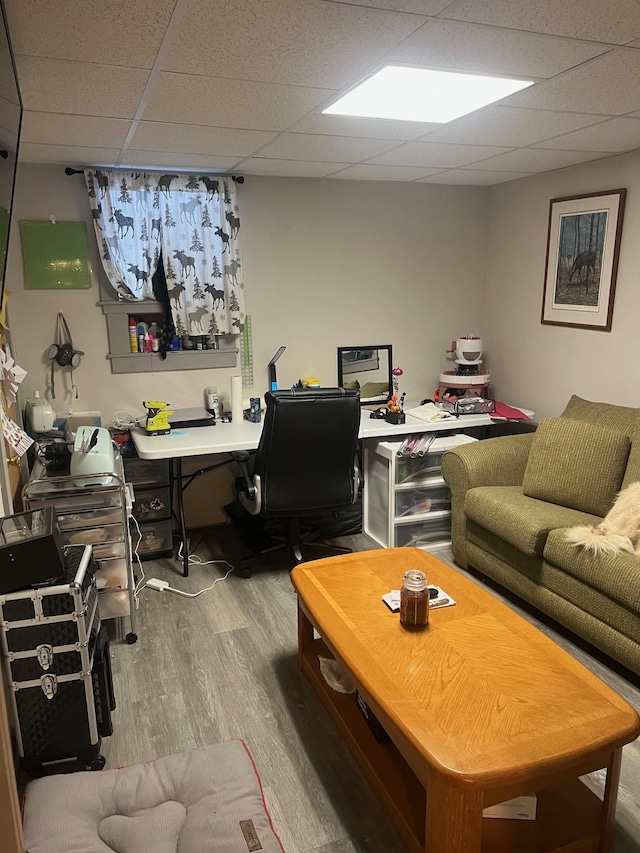 office with wood finished floors and a paneled ceiling