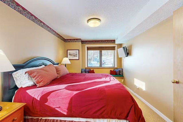 bedroom featuring a textured ceiling, carpet floors, and baseboards