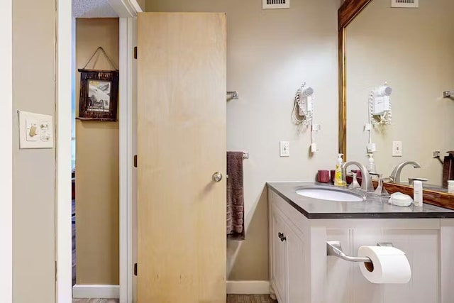 bathroom with baseboards, visible vents, and vanity