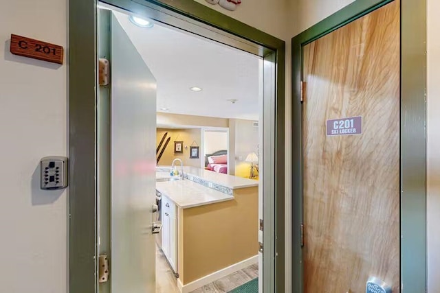 hall featuring a sink and recessed lighting