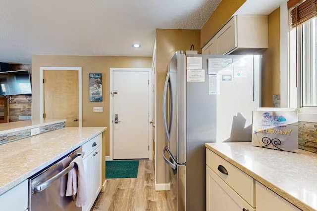 kitchen with light countertops, appliances with stainless steel finishes, recessed lighting, and light wood-style floors