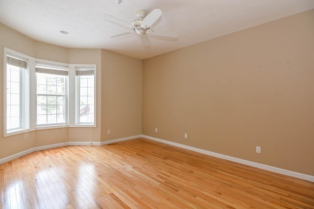 unfurnished room with light wood-style floors, ceiling fan, and baseboards