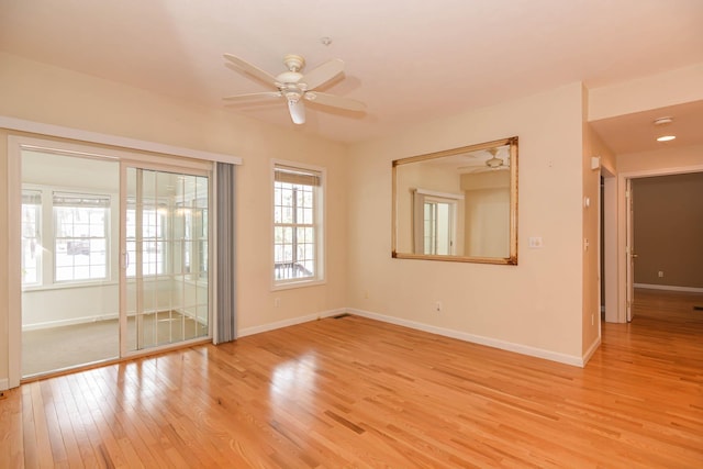 empty room with light wood-style floors, baseboards, and a ceiling fan