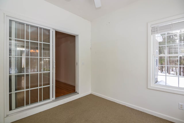 spare room with carpet flooring, a ceiling fan, and baseboards