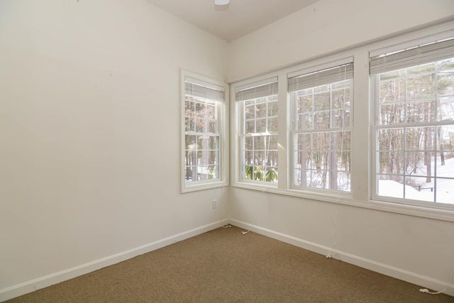 empty room featuring dark carpet and baseboards