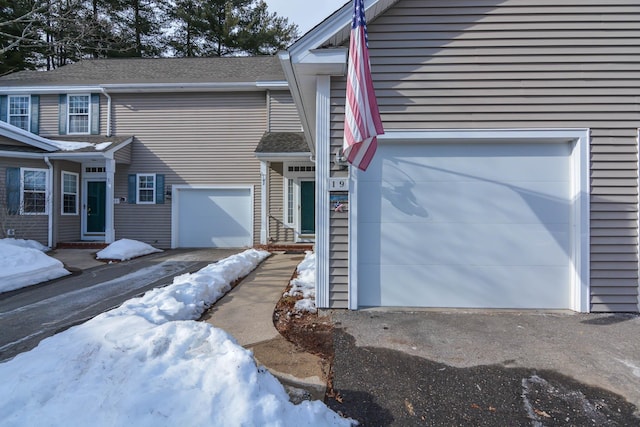 snow covered property with driveway