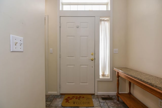 entrance foyer with stone finish floor, visible vents, and baseboards