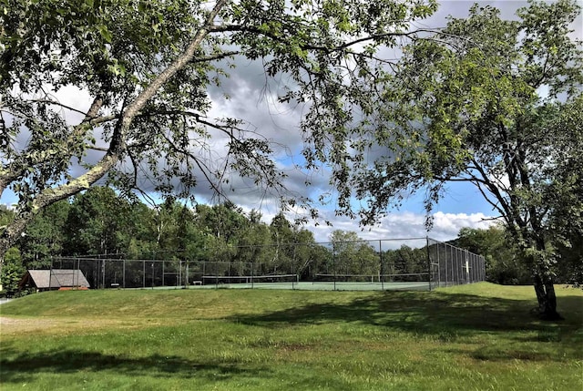 view of yard featuring a tennis court and fence