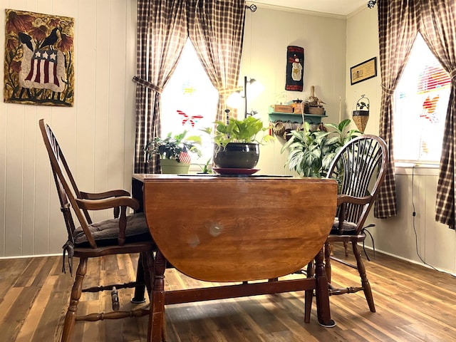 dining area with crown molding and wood finished floors