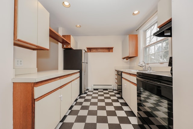 kitchen with dark floors, a baseboard heating unit, a sink, white cabinetry, and black appliances