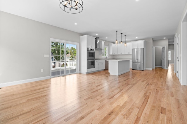 unfurnished living room with light wood-type flooring, baseboards, and recessed lighting