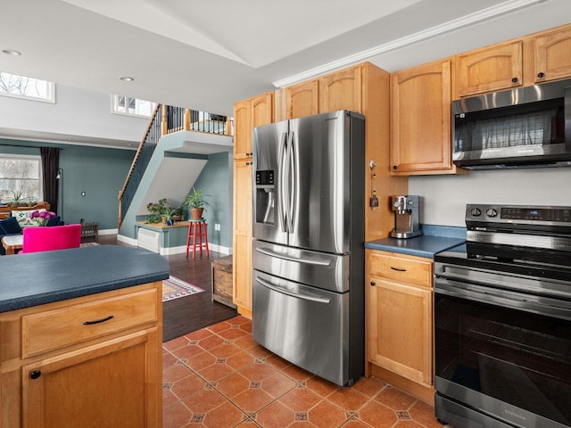 kitchen featuring stainless steel appliances, dark tile patterned floors, baseboards, vaulted ceiling, and dark countertops