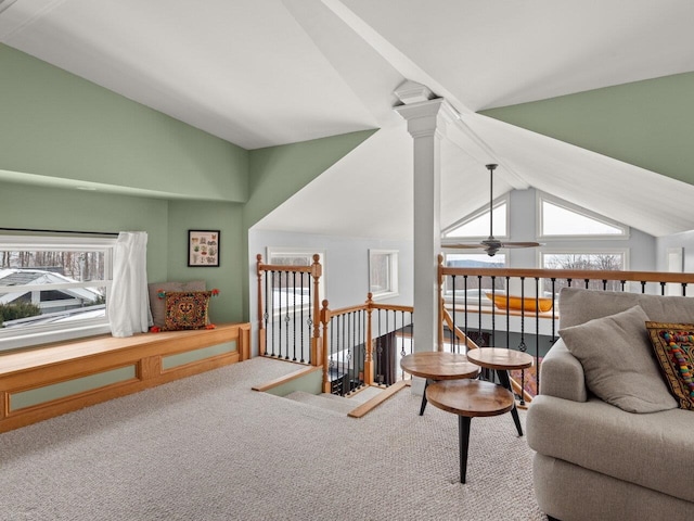 living area featuring lofted ceiling, ceiling fan, carpet, and an upstairs landing