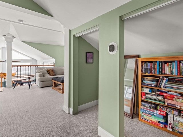 hall with vaulted ceiling, carpet flooring, and baseboards