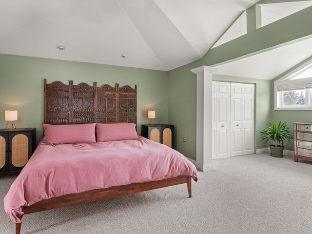 bedroom with carpet floors, lofted ceiling, a closet, and baseboards