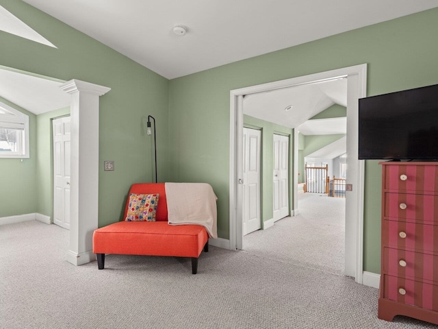 sitting room featuring lofted ceiling, carpet floors, decorative columns, and baseboards