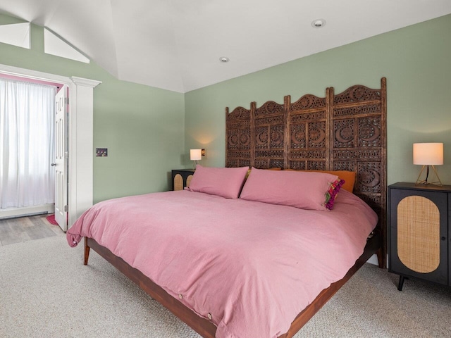 bedroom with carpet, a baseboard radiator, and vaulted ceiling