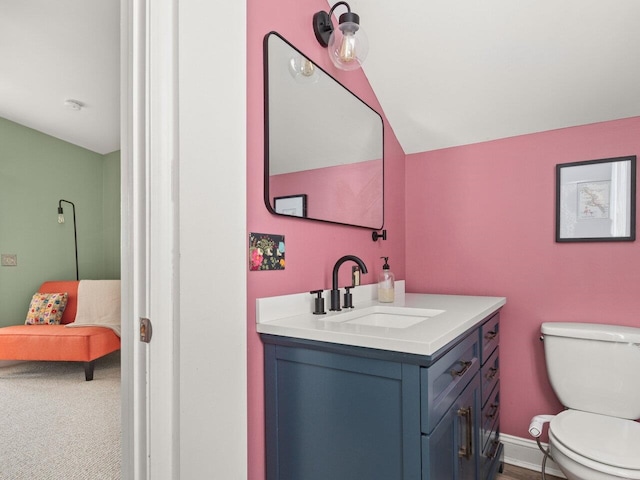 bathroom featuring baseboards, vanity, and toilet