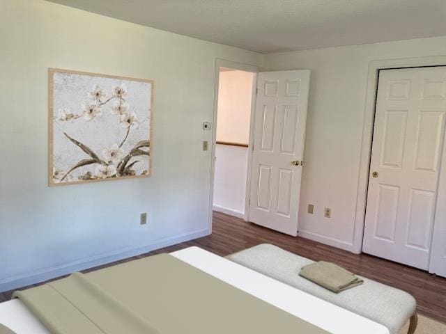 bedroom with baseboards and dark wood-style flooring